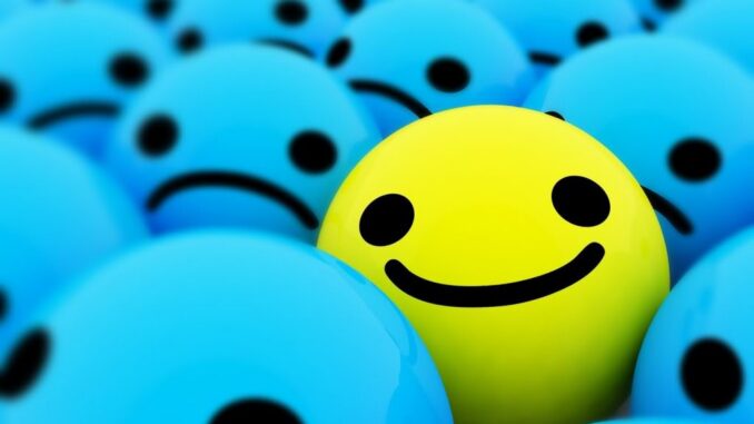 An image of a bunch of smiley being blue and sad, with one yellow happy one mixed in.